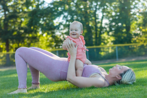 Mother and baby doing baby yoga postpartum, or perhaps three to six months post-birth